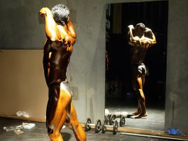 Bodybuilder posing in front of a mirror