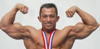 7 Ways to Get Bigger Muscles Fast Bodybuilder with medal doing a double bicep pose