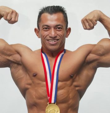 Bodybuilder with medal doing a double bicep pose