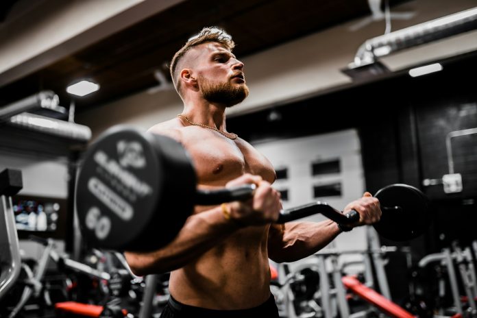 Bodybuilding with barbell curls. Photo by Anastase Maragos on Unsplash