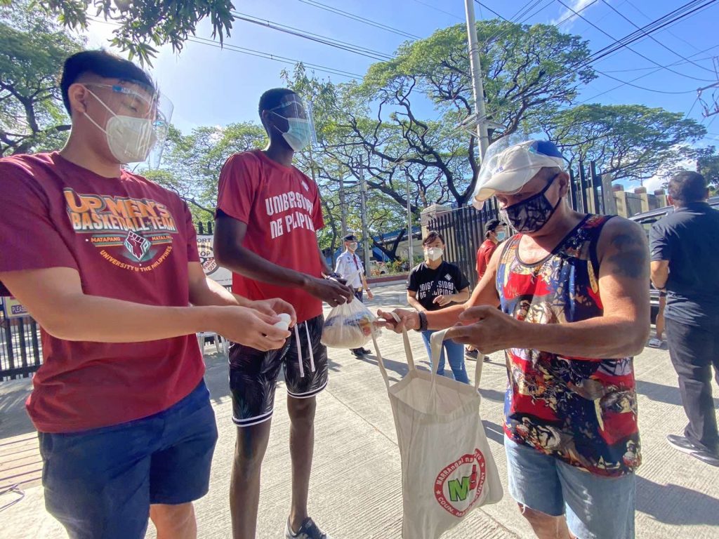 Bismarck Lina and Malick Diouf distributing goods in a community pantry in UP Diliman