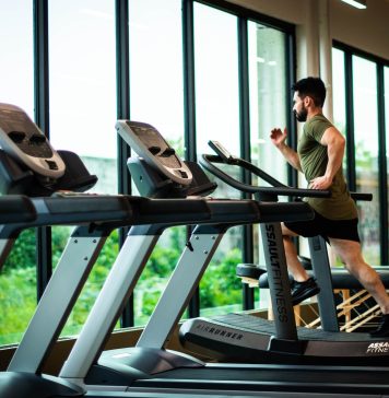 Bodybuilding for Busy Professionals. Man running on a threadmill in a hotel gym
