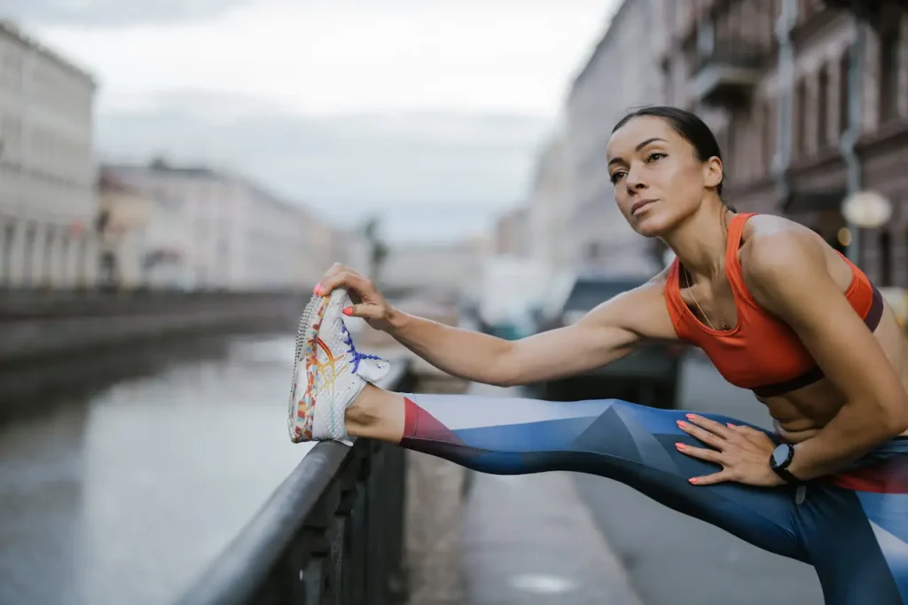 Best Early Morning Workouts to Beat the Summer Heat 1 A Woman Wearing Leggings and Sports Bra while Stretching Her Legs